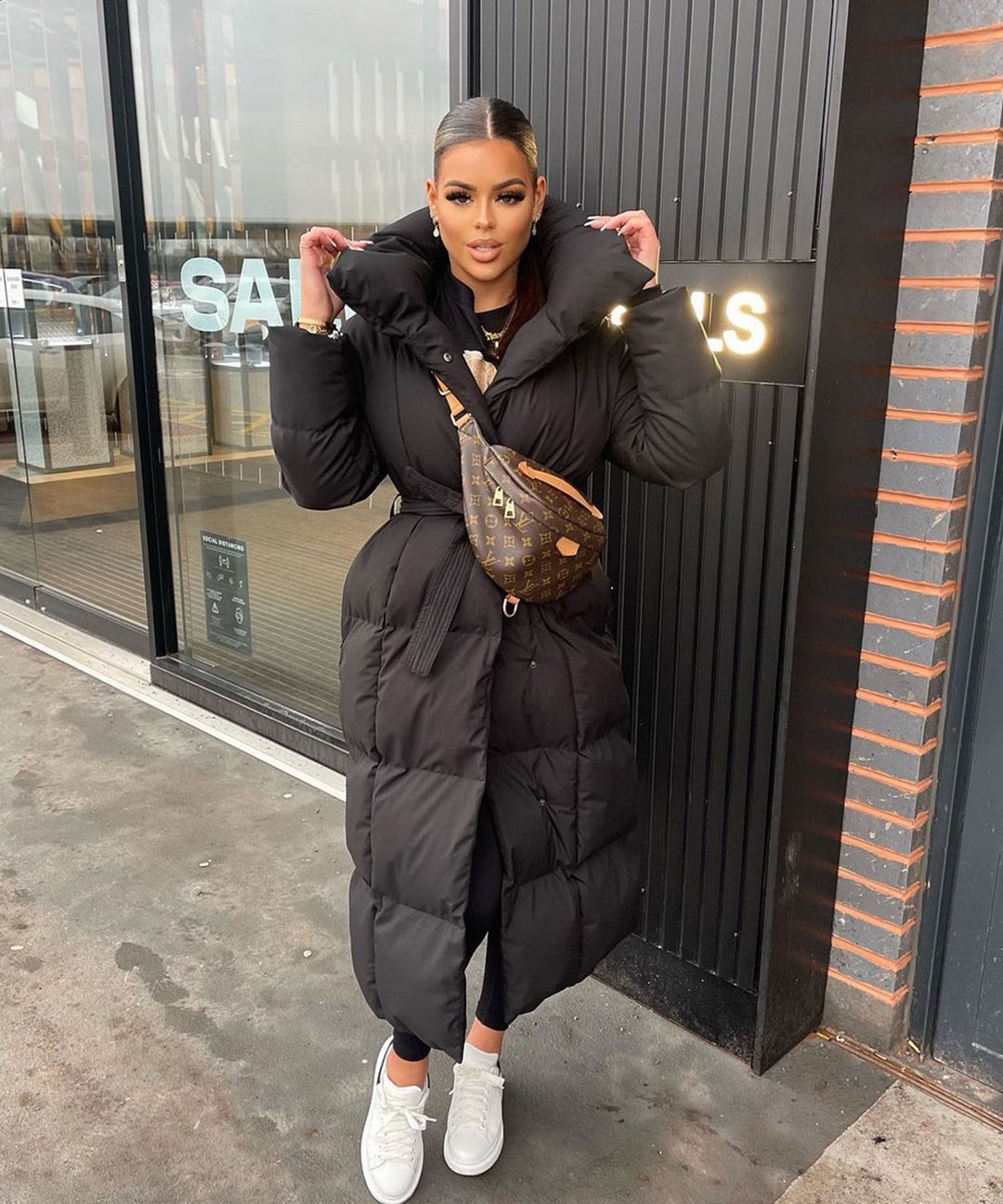 Women's black long belted puffer coat with raised collar