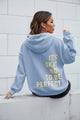 Women's long-sleeve hooded sweatshirt with stacked text graphic on the back