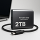 Portable 2TB external SSD with USB-C cable and rounded dark housing