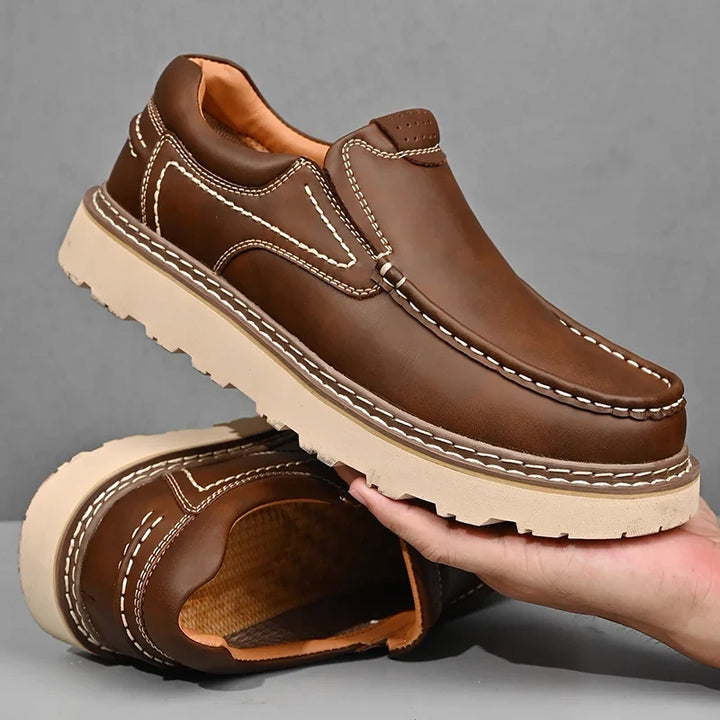 Brown and black moc-toe loafers with contrast stitching and lug soles