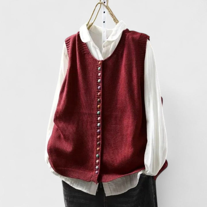 Women's sleeveless button front sweater vest layered over a shirt