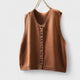 Women's sleeveless button front sweater vest layered over a shirt