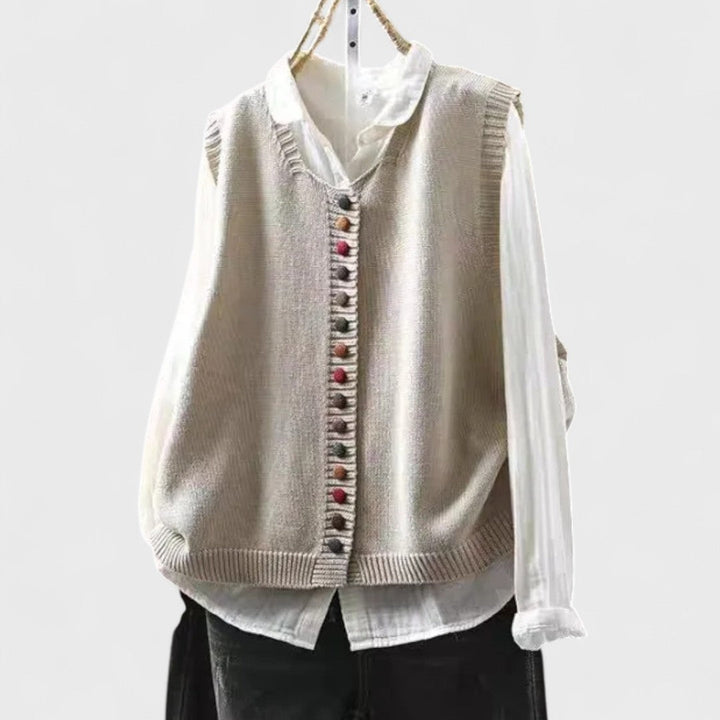 Women's sleeveless button front sweater vest layered over a shirt
