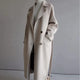 Women's longline button-front coat with notched lapels and side pockets