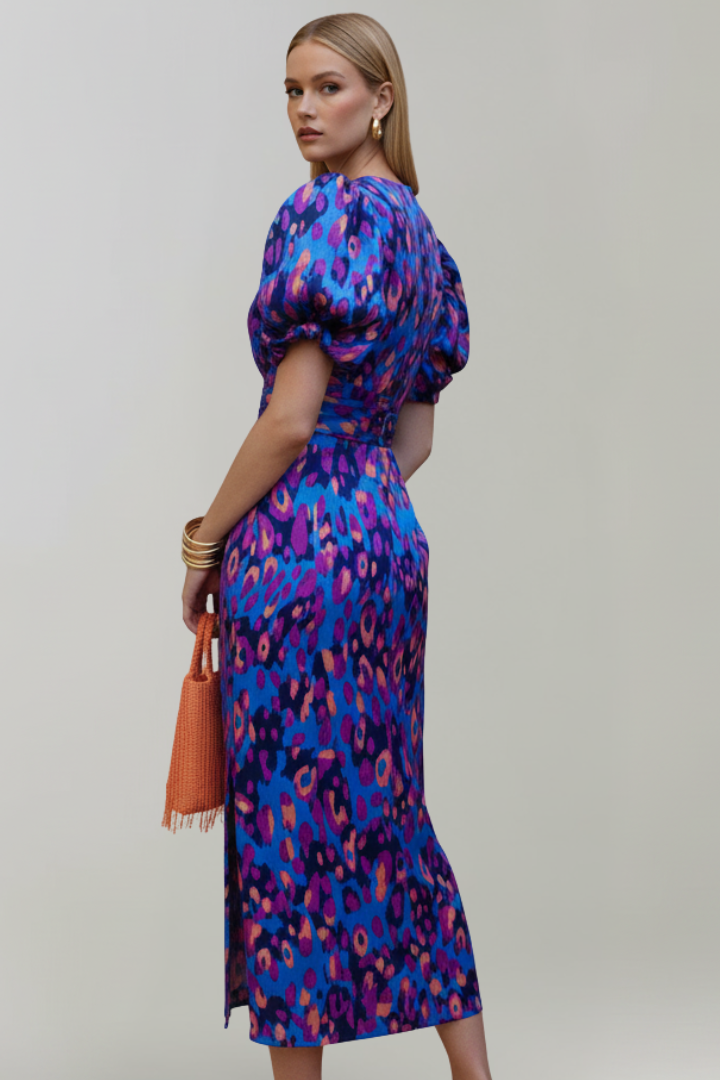 Woman wearing an abstract print midi dress with puff sleeves and ruched waist