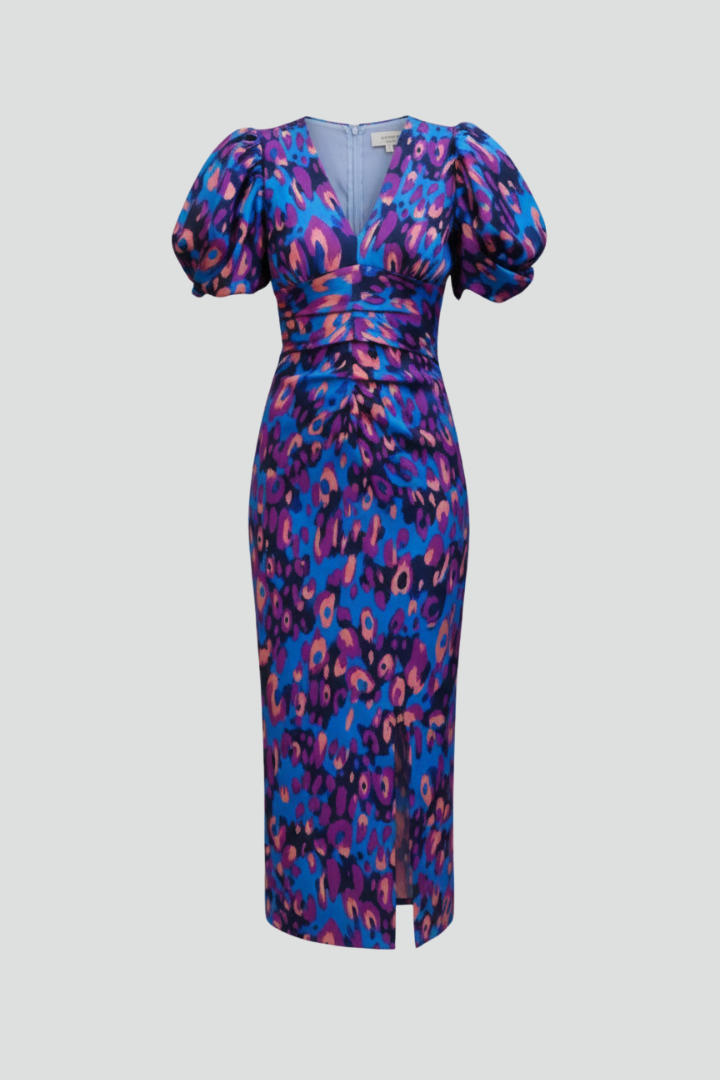 Woman wearing an abstract print midi dress with puff sleeves and ruched waist