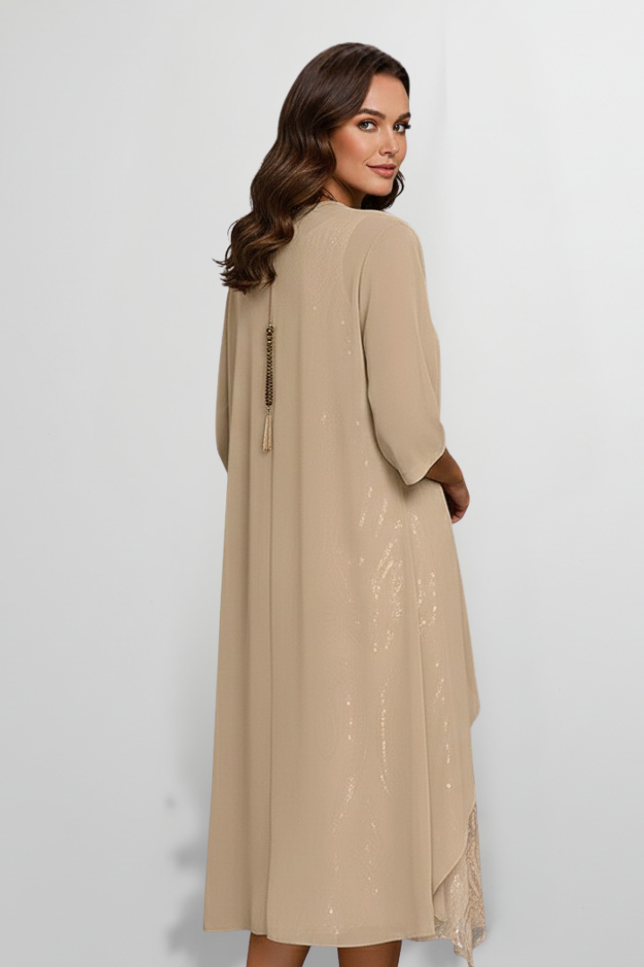 Woman wearing a beige sequin midi dress with attached cape sleeve overlay