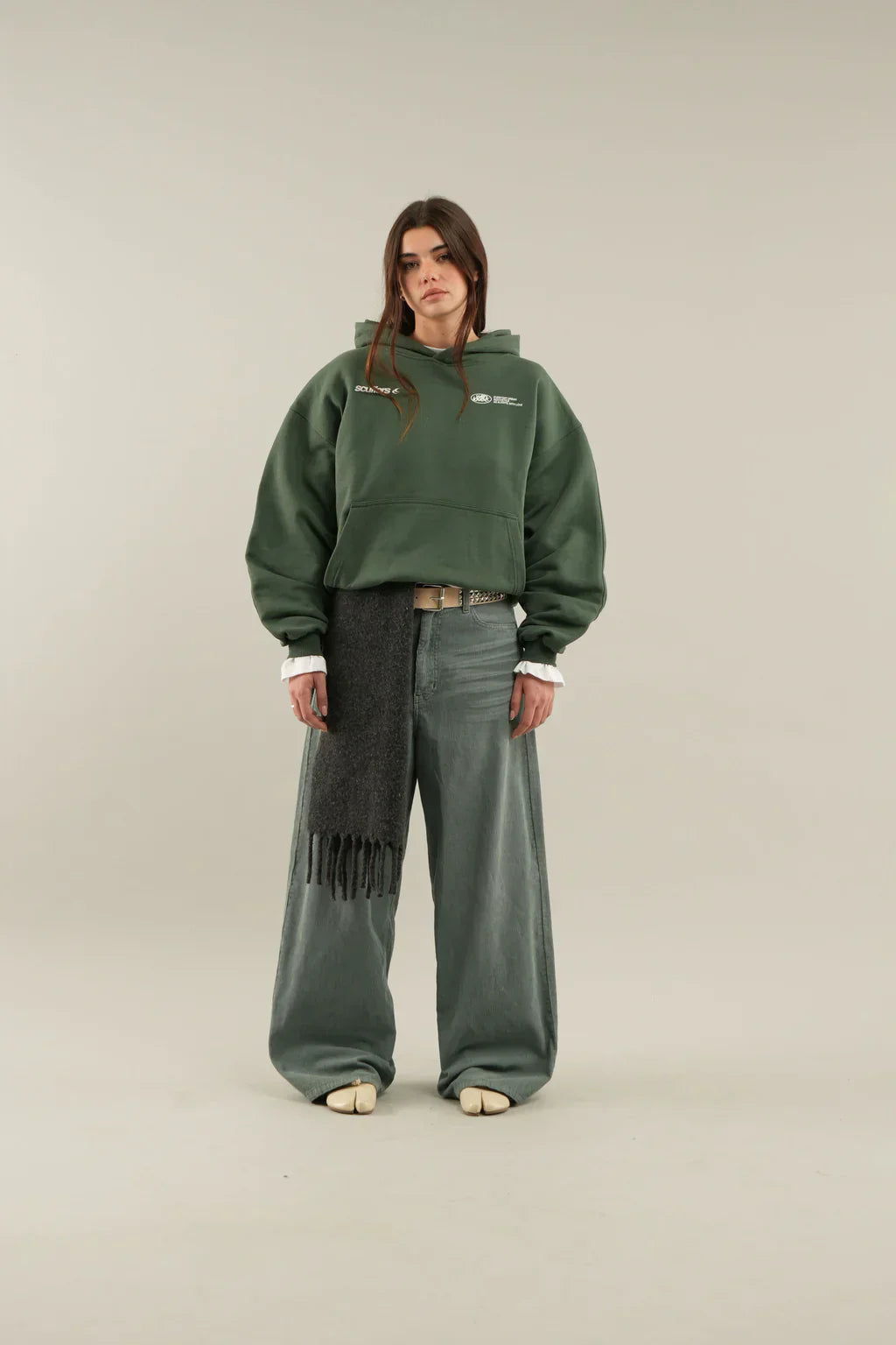 Woman wearing a relaxed hooded sweatshirt with a front pouch pocket