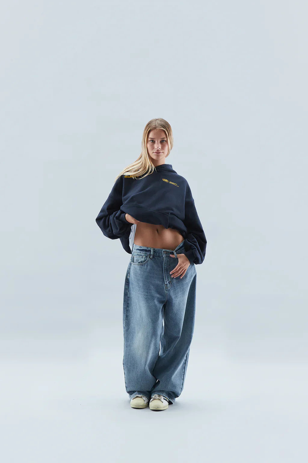 Woman wearing a relaxed hooded sweatshirt with a front pouch pocket