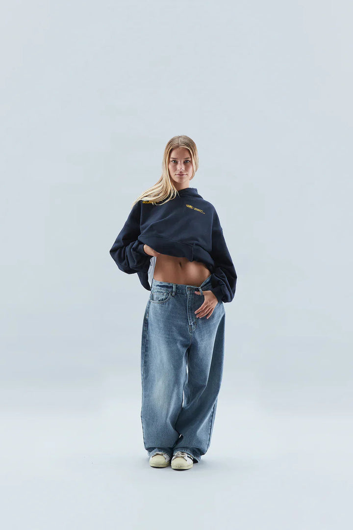 Woman wearing a relaxed hooded sweatshirt with a front pouch pocket