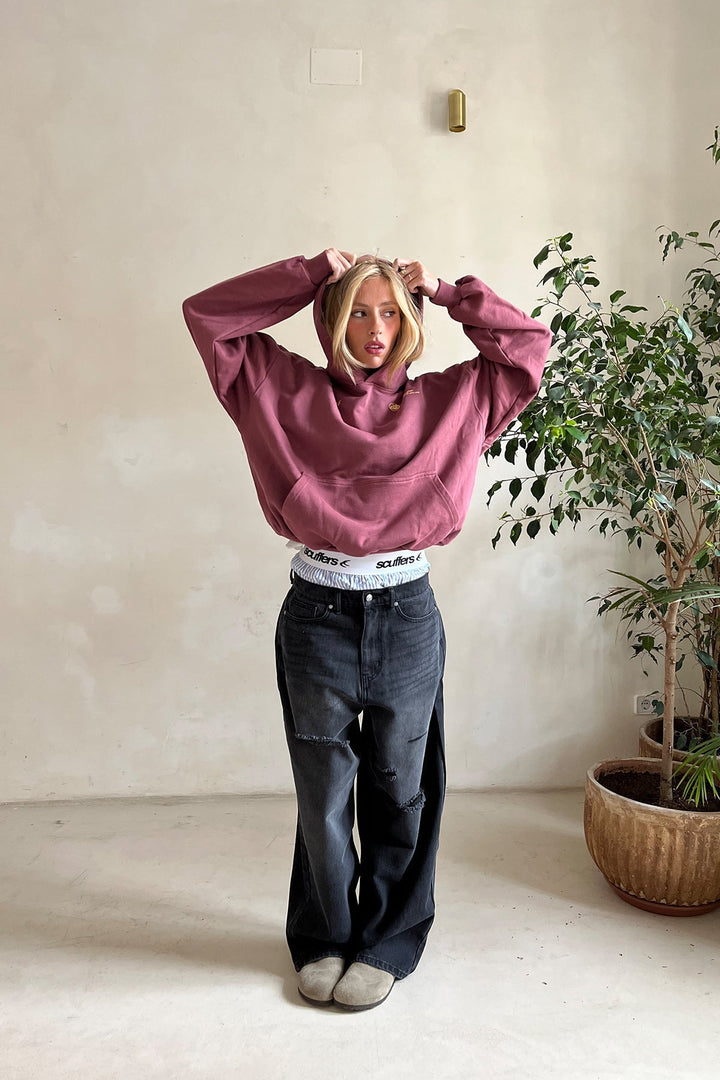 Woman wearing a relaxed hooded sweatshirt with a front pouch pocket