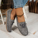 Women's low-profile lace-up moccasin shoes with stitched trim and flat textured soles