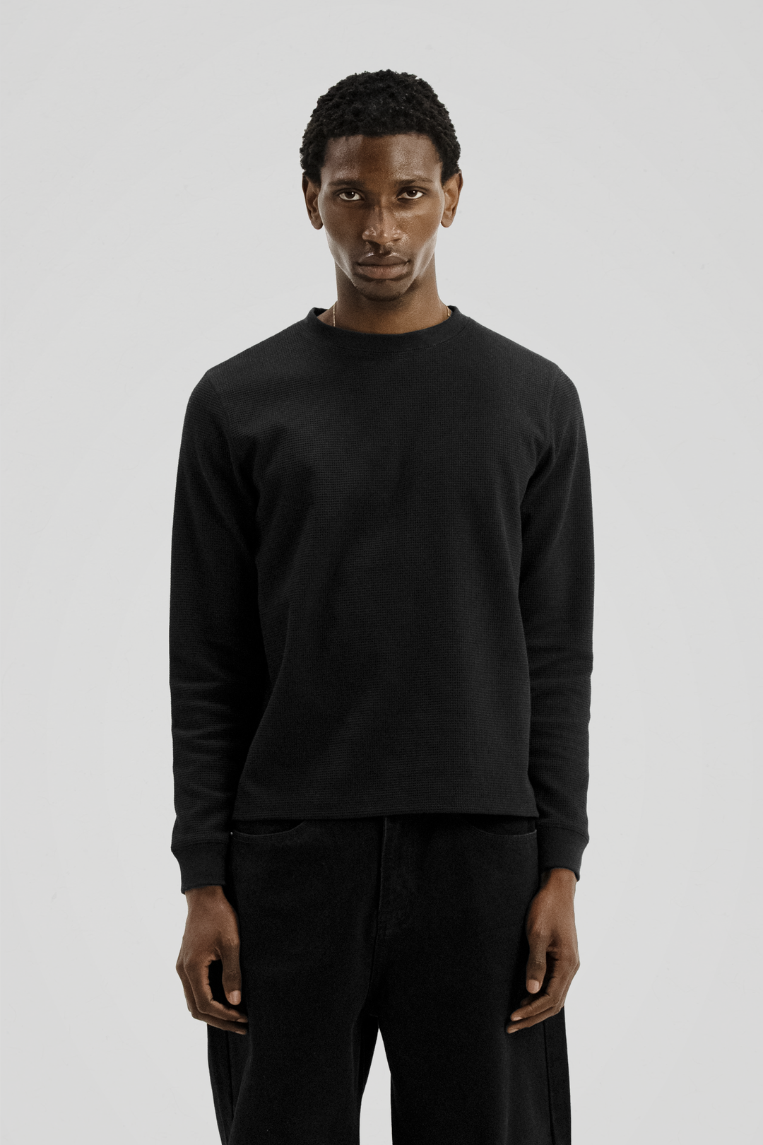 Black long sleeve crew neck top with ribbed cuffs and hem