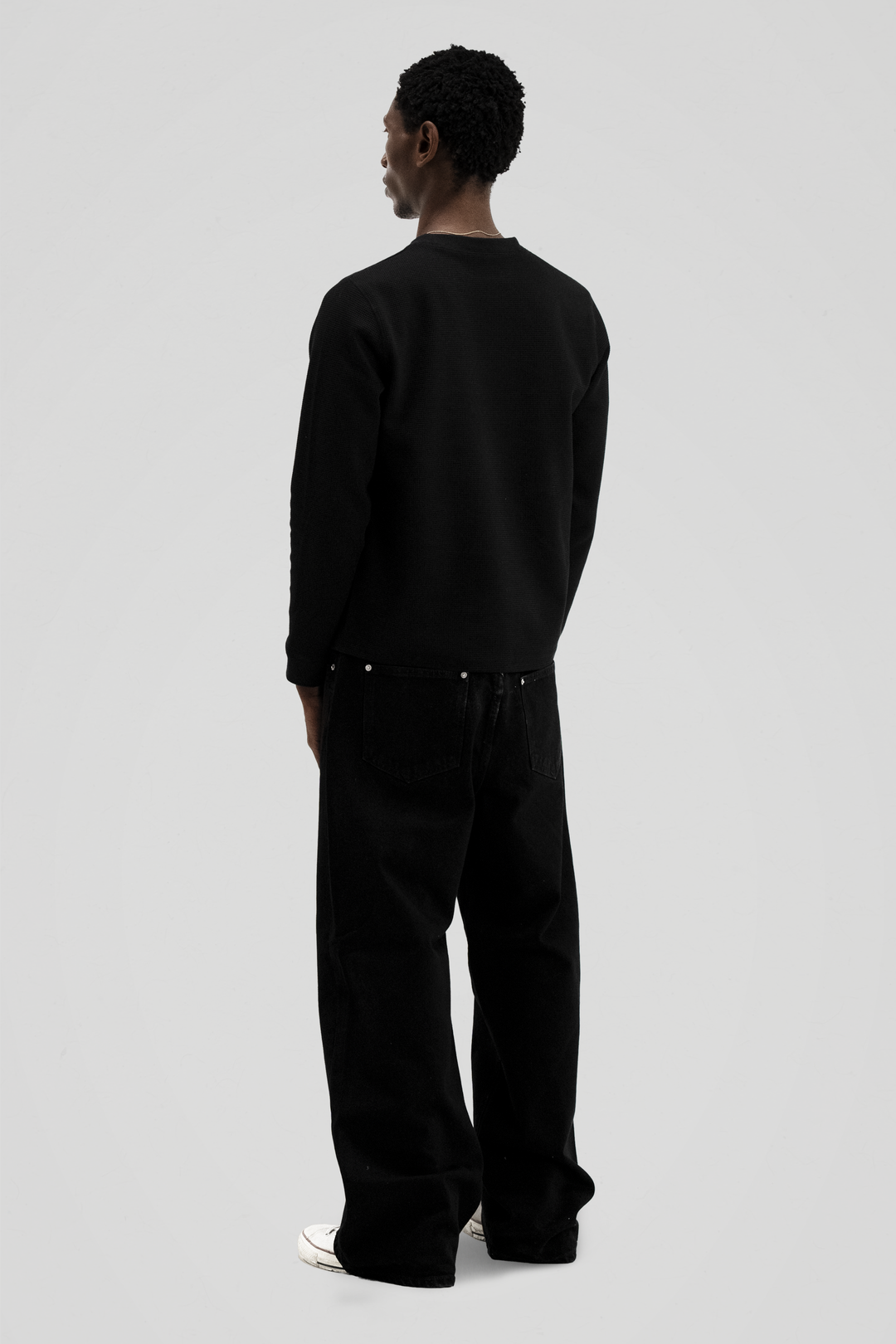 Black long sleeve crew neck top with ribbed cuffs and hem
