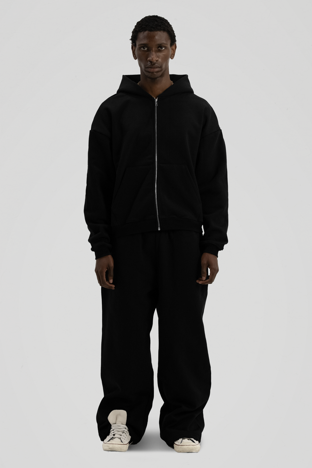 Man wearing a black full-zip hooded sweatshirt with a kangaroo pocket