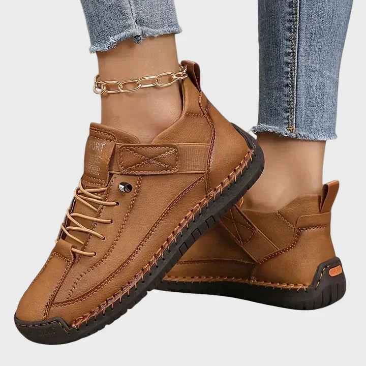 Orthopedic sneakers with white upper and beige sole, worn with jeans