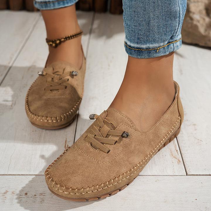 Women's low-profile lace-up moccasin shoes with stitched trim and flat textured soles