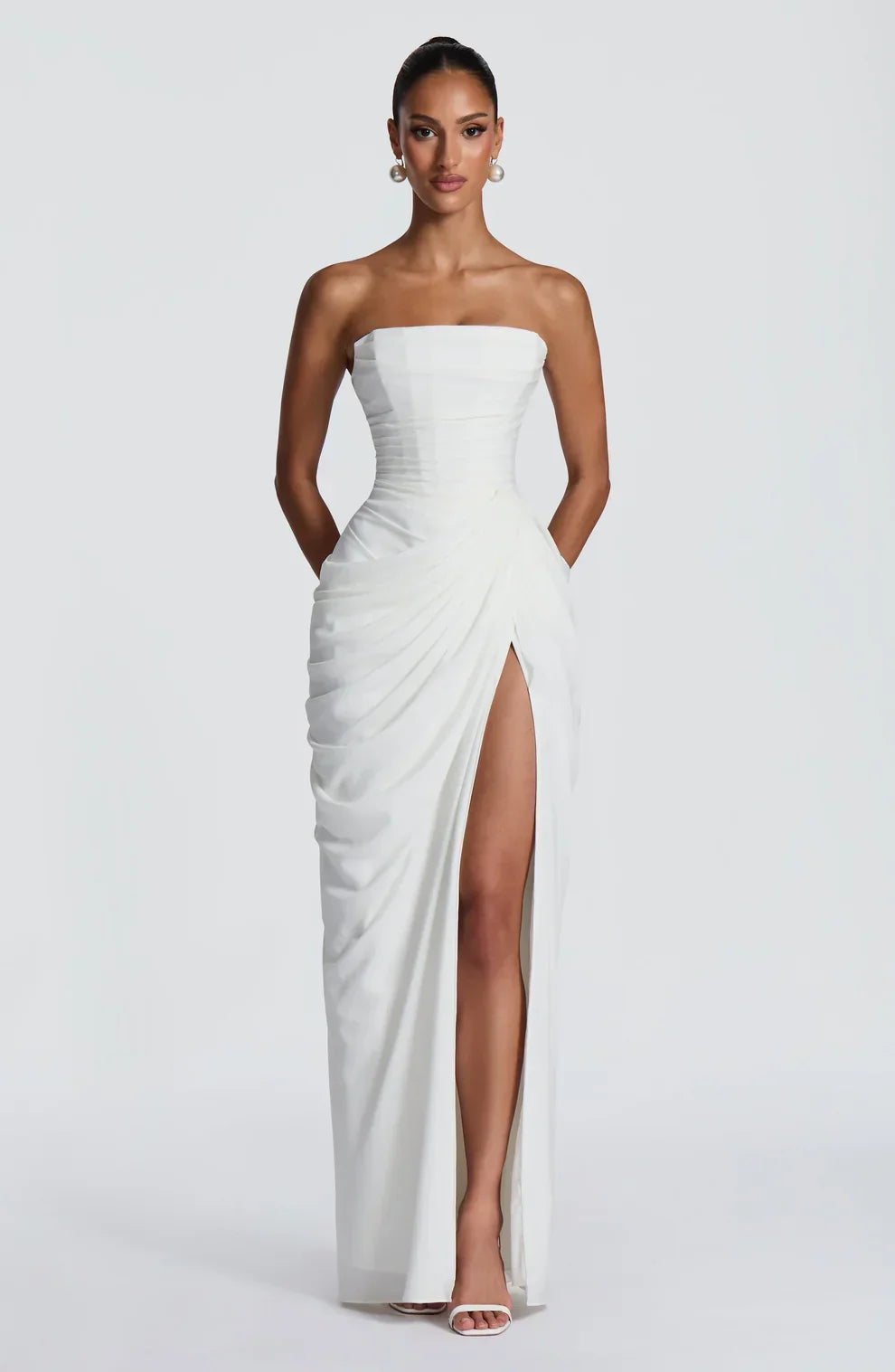Woman wearing strapless ruched maxi dress with high side slit in yellow and navy versions