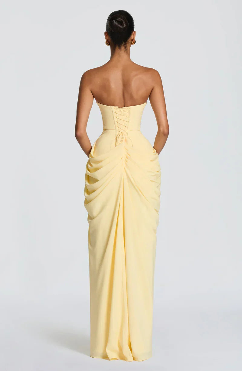 Woman wearing strapless ruched maxi dress with high side slit in yellow and navy versions