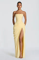 Woman wearing strapless ruched maxi dress with high side slit in yellow and navy versions