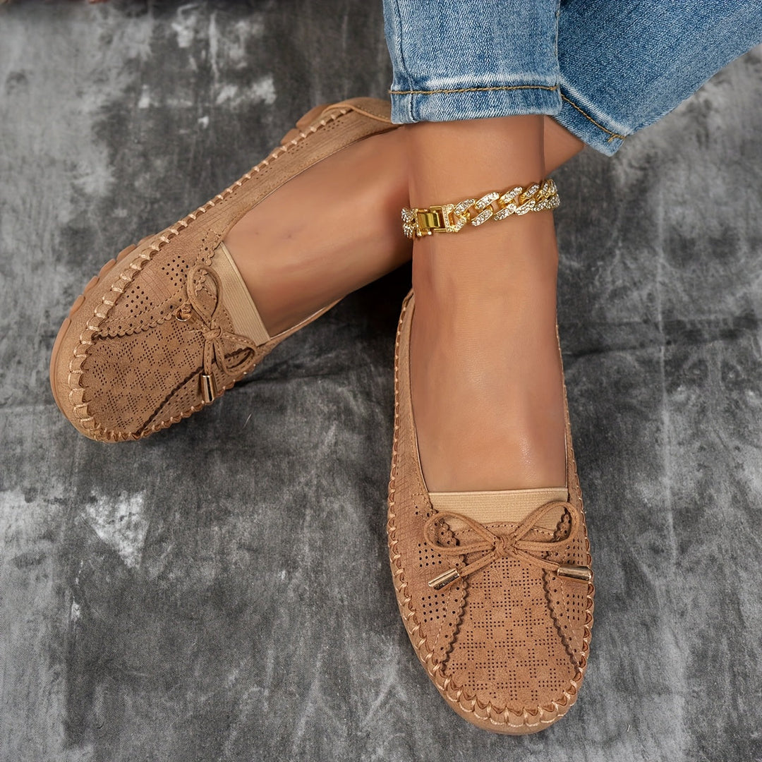 Women's perforated loafers with decorative bows and flat segmented soles