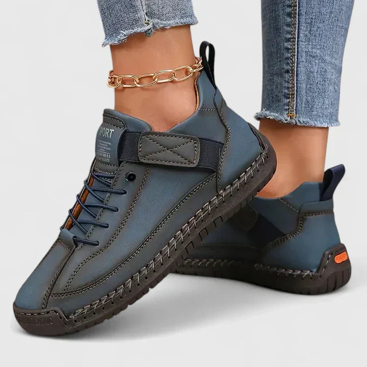 Orthopedic sneakers with white upper and beige sole, worn with jeans