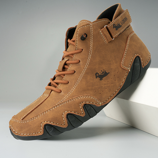 Unisex lace-up ankle boot with rounded toe, side strap detail and wavy textured sole