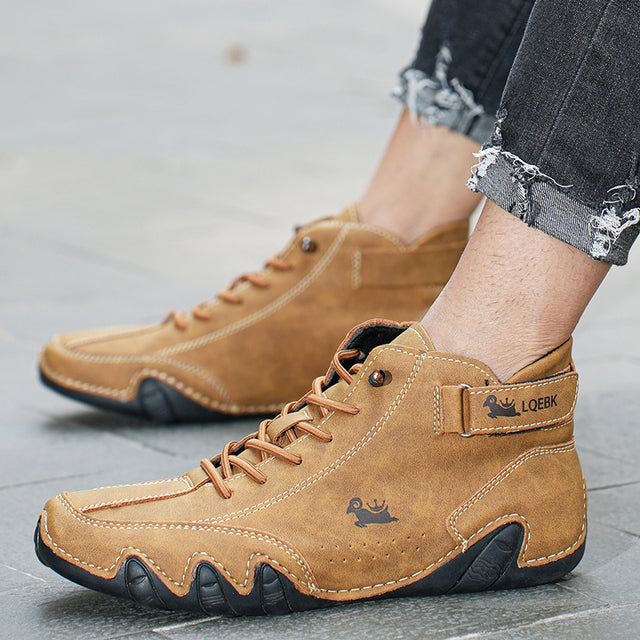 Unisex lace-up ankle boot with rounded toe, side strap detail and wavy textured sole
