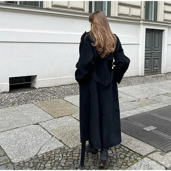 Woman wearing a black double-breasted long trench coat