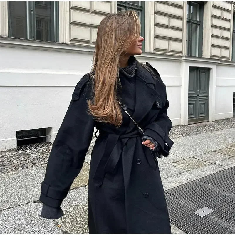Woman wearing a black double-breasted long trench coat