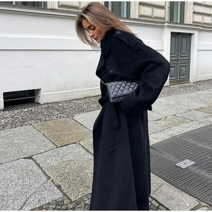 Woman wearing a black double-breasted long trench coat