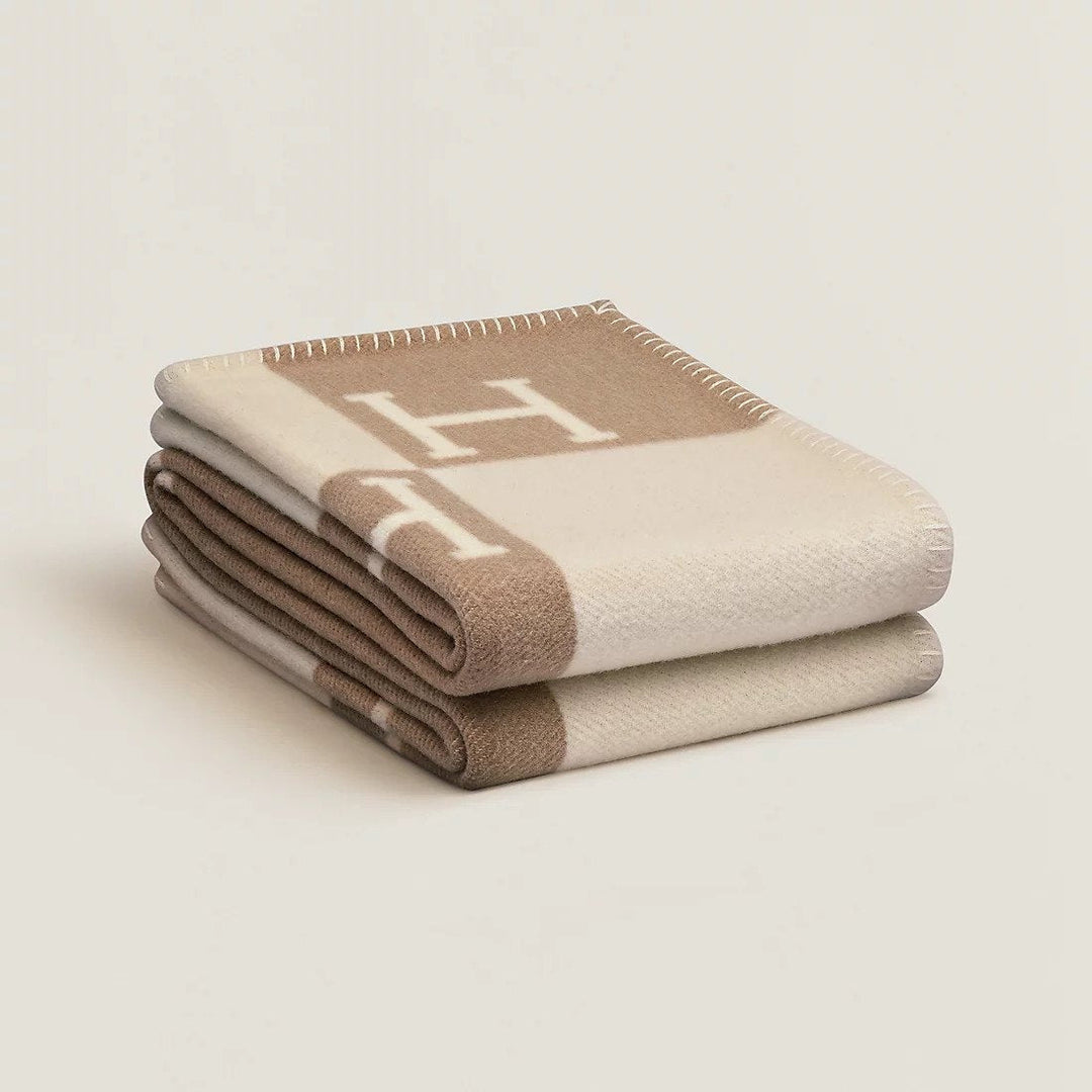 Folded rectangular throw blanket with contrasting blocks and letter motifs