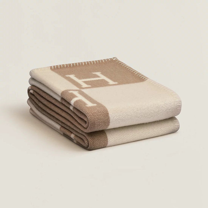 Folded rectangular throw blanket with contrasting blocks and letter motifs