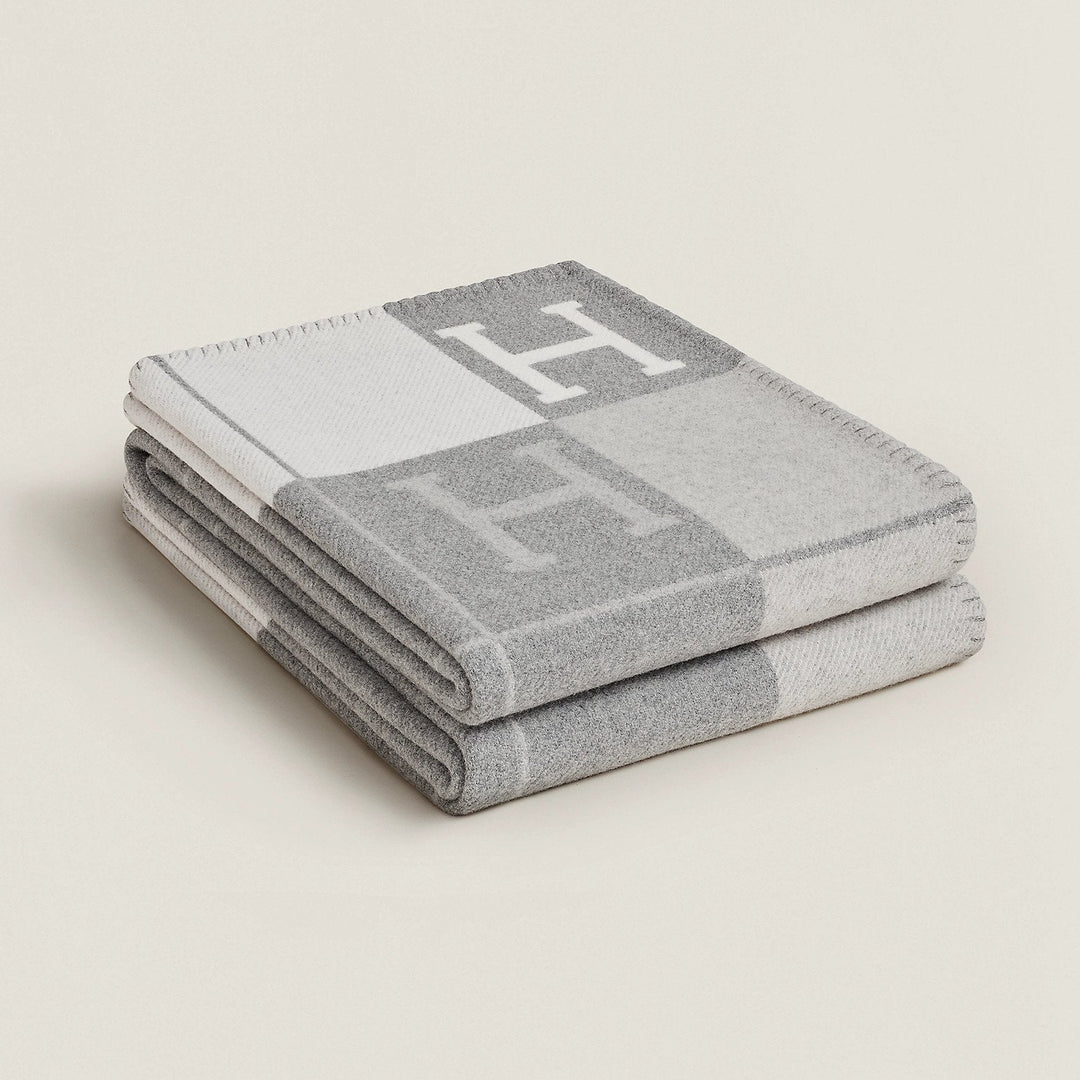 Folded rectangular throw blanket with contrasting blocks and letter motifs