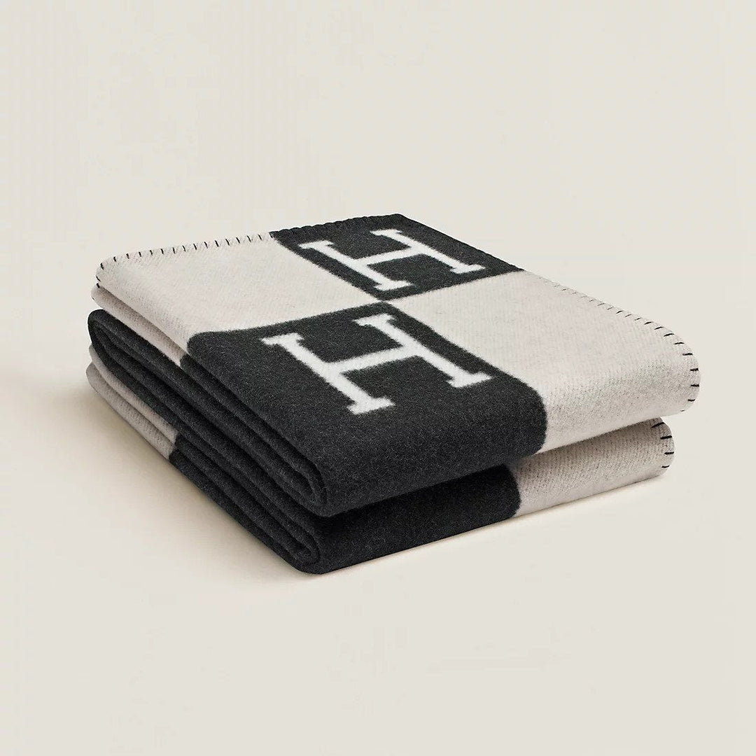Folded rectangular throw blanket with contrasting blocks and letter motifs