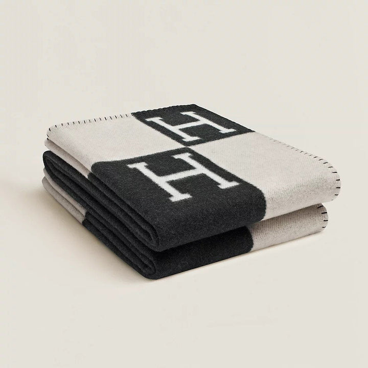 Folded rectangular throw blanket with contrasting blocks and letter motifs