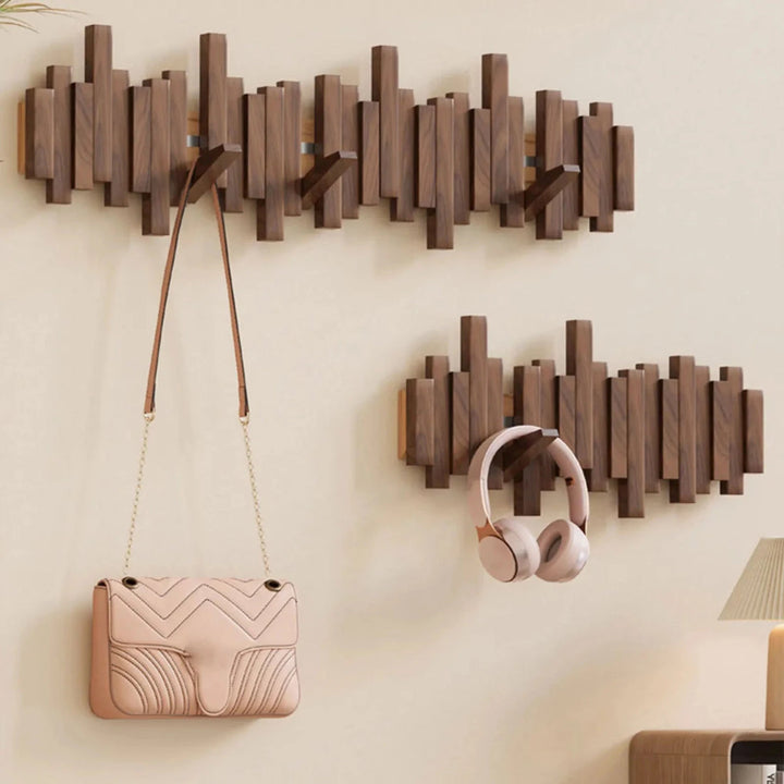 Wall-mounted wooden coat rack with staggered piano-style slats and angled hooks