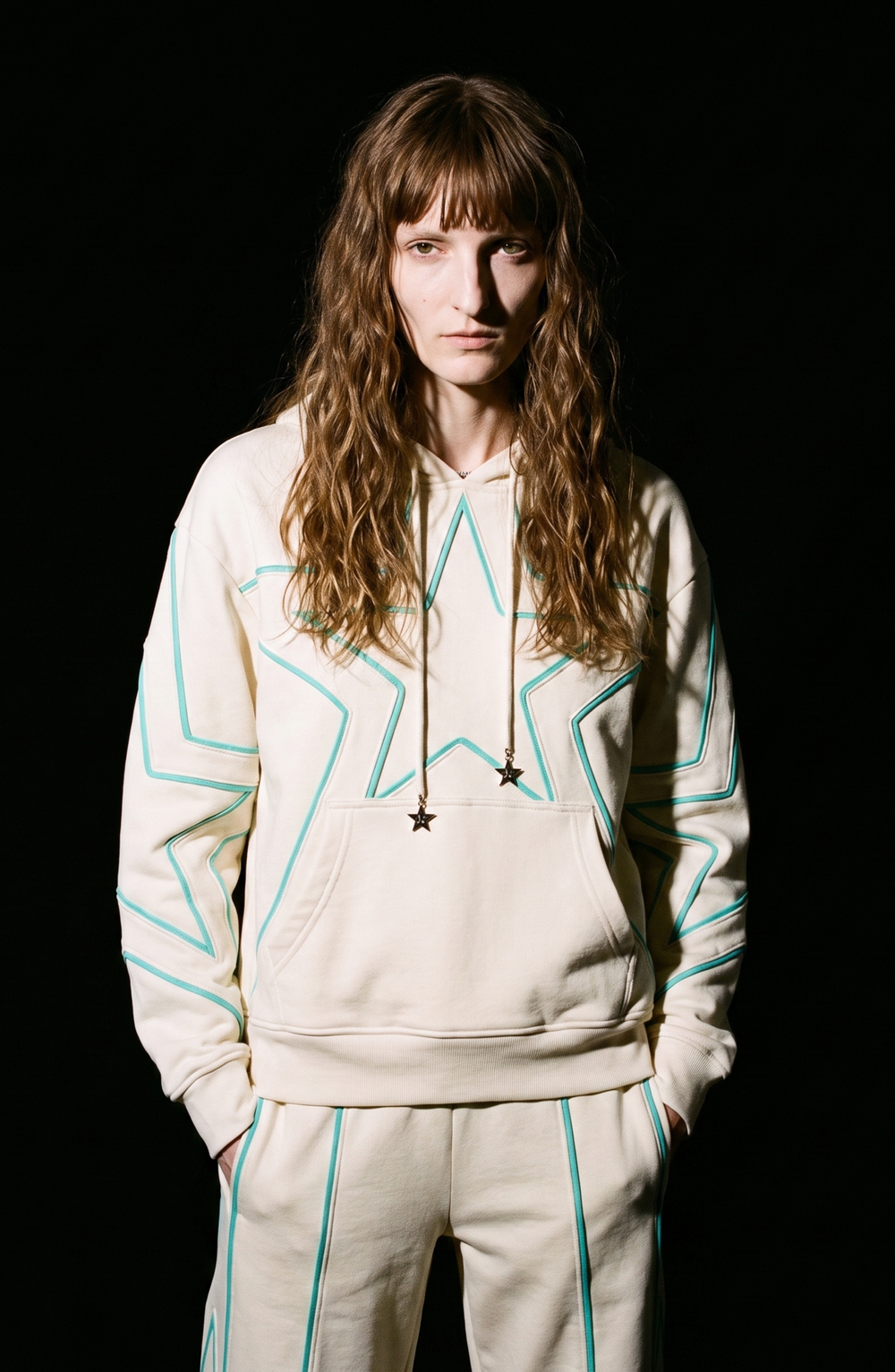Cream hoodie with turquoise outlined star detailing, drawstring hood and kangaroo pocket