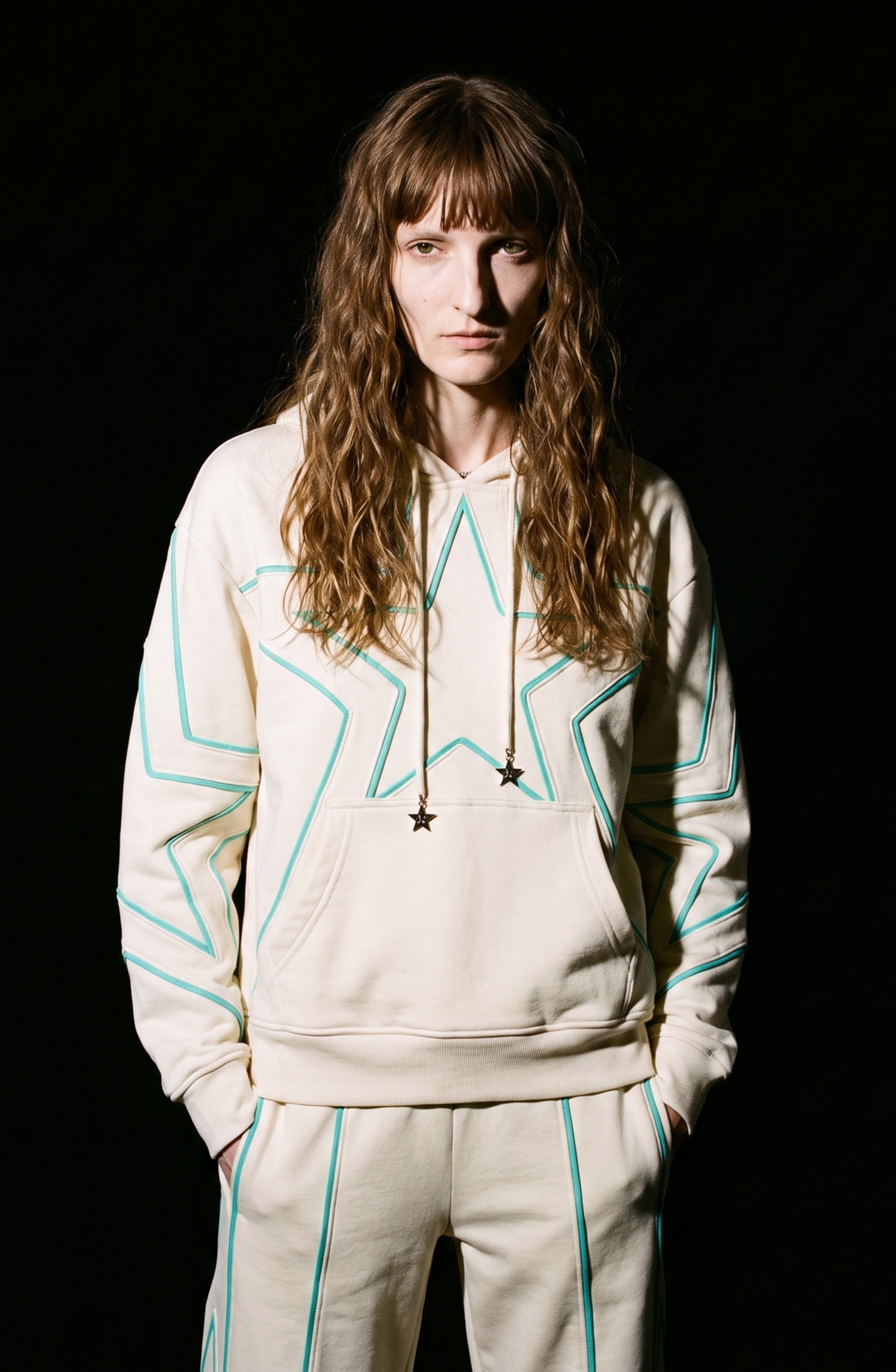 Cream hoodie with turquoise outlined star detailing, drawstring hood and kangaroo pocket