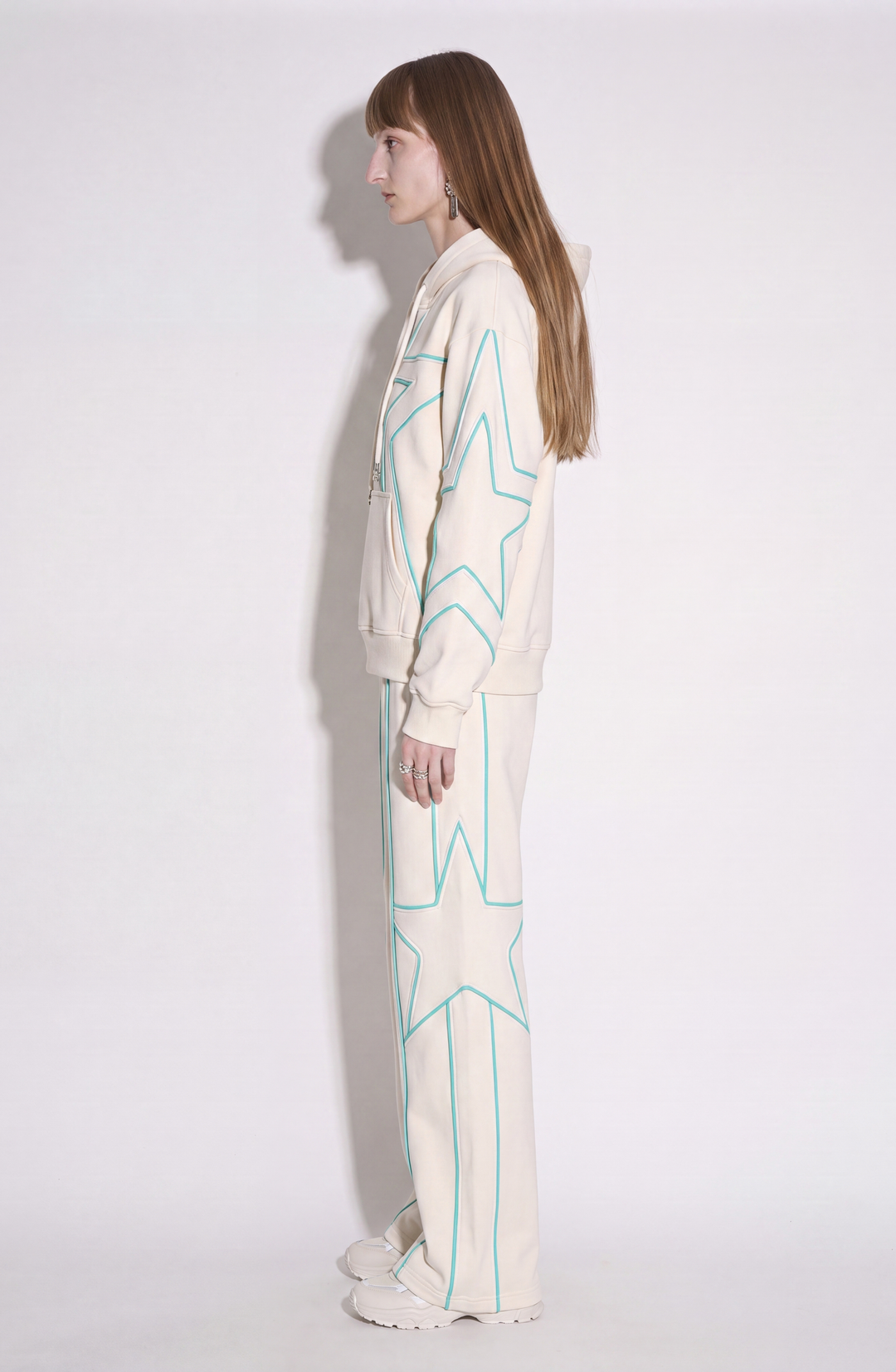 Cream hoodie with turquoise outlined star detailing, drawstring hood and kangaroo pocket