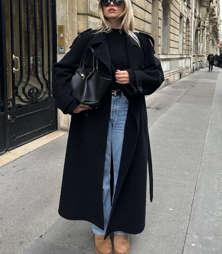 Woman wearing a black double-breasted long trench coat