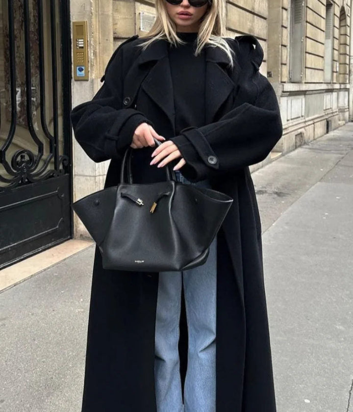 Woman wearing a black double-breasted long trench coat