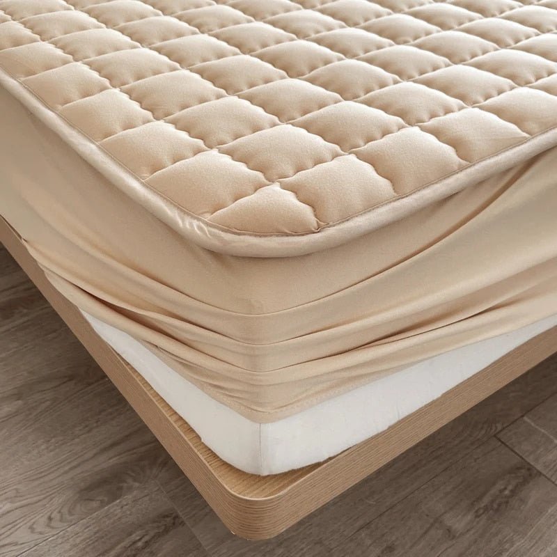 Quilted mattress topper with a padded square pattern on a bed
