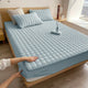 Quilted mattress topper with a padded square pattern on a bed