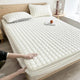 Quilted mattress topper with a padded square pattern on a bed