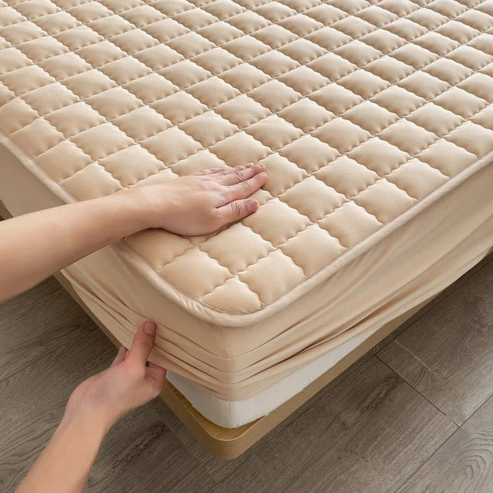 Quilted mattress topper with a padded square pattern on a bed
