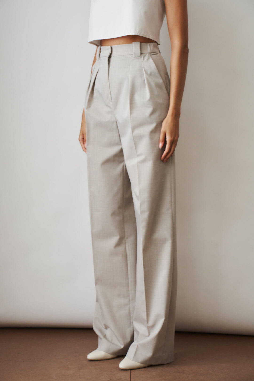 Women's beige high-rise wide-leg pants with front pleats and side pockets