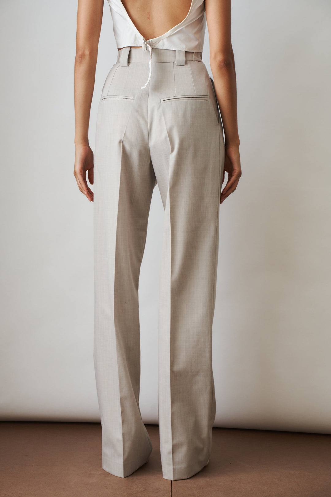 Women's beige high-rise wide-leg pants with front pleats and side pockets