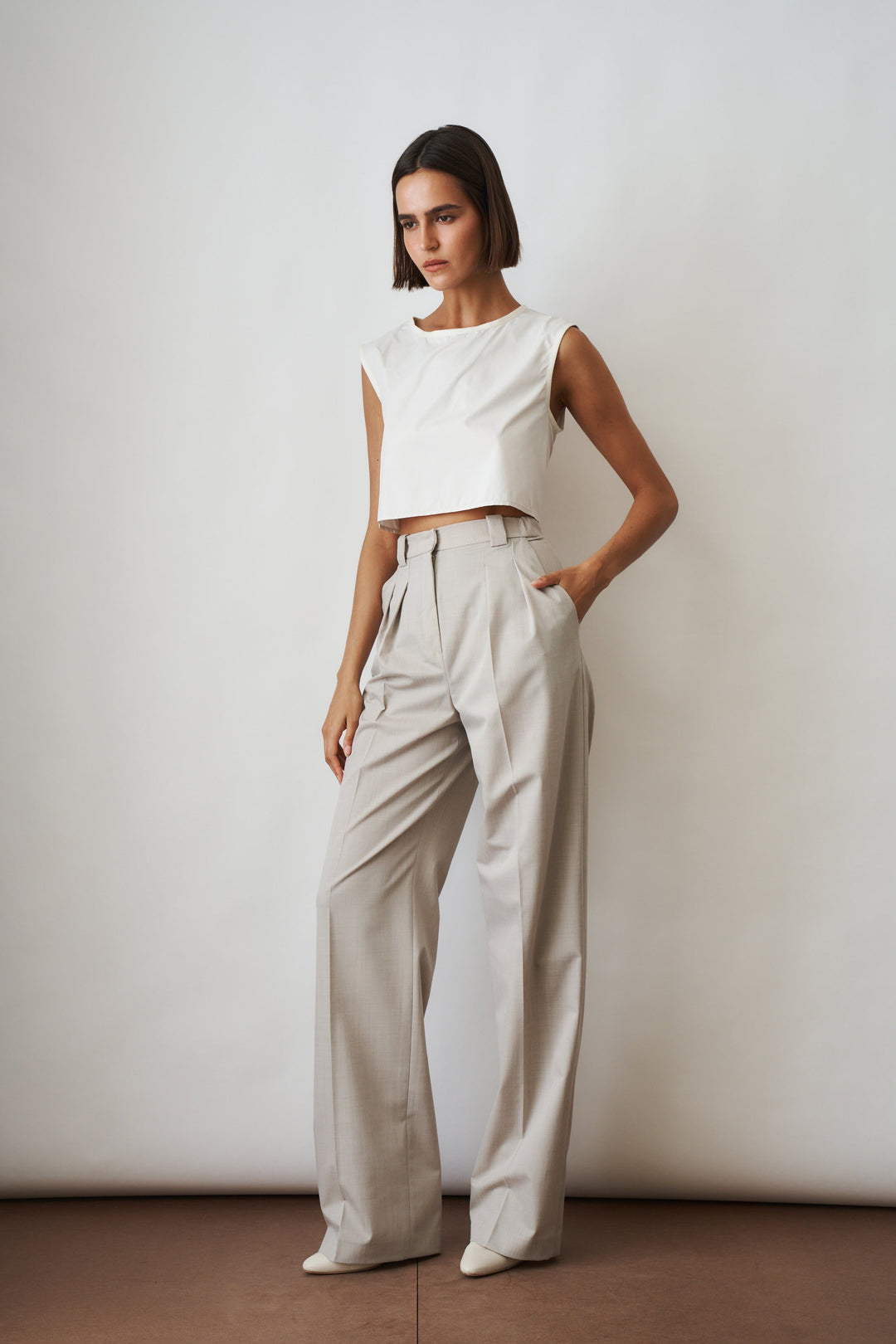 Women's beige high-rise wide-leg pants with front pleats and side pockets