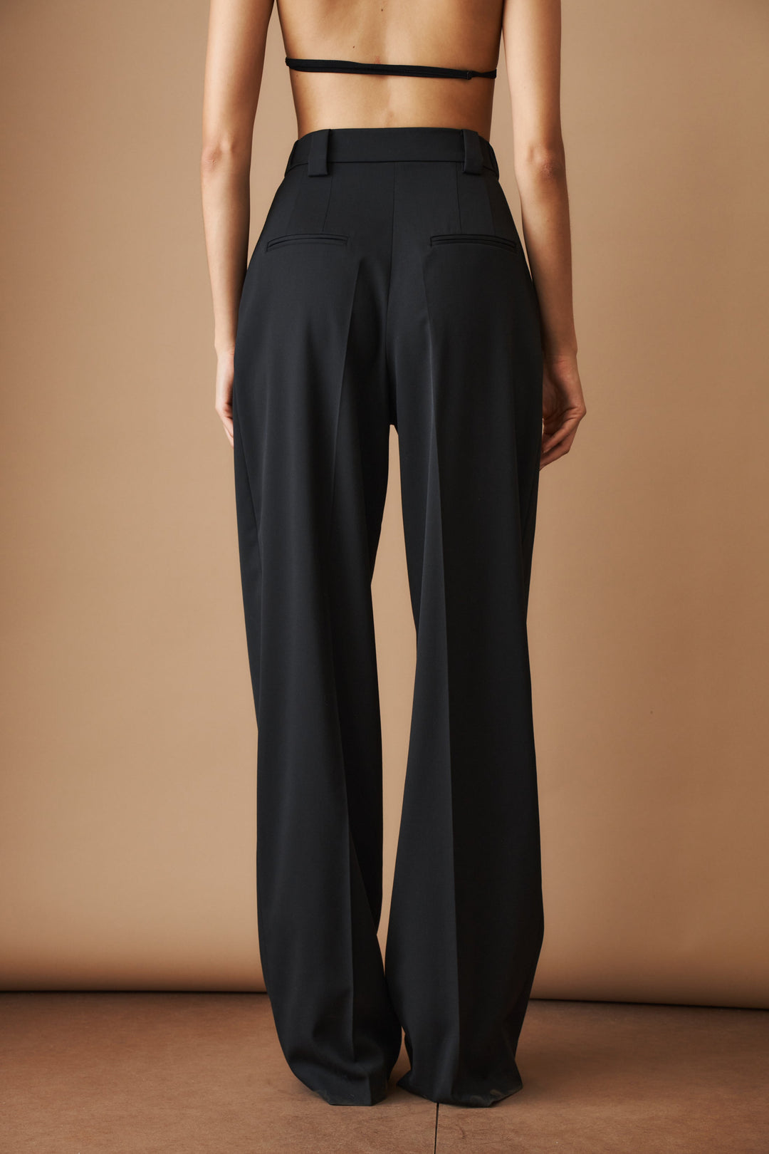 Women's black high-waisted pleated wide-leg pants with belt loops